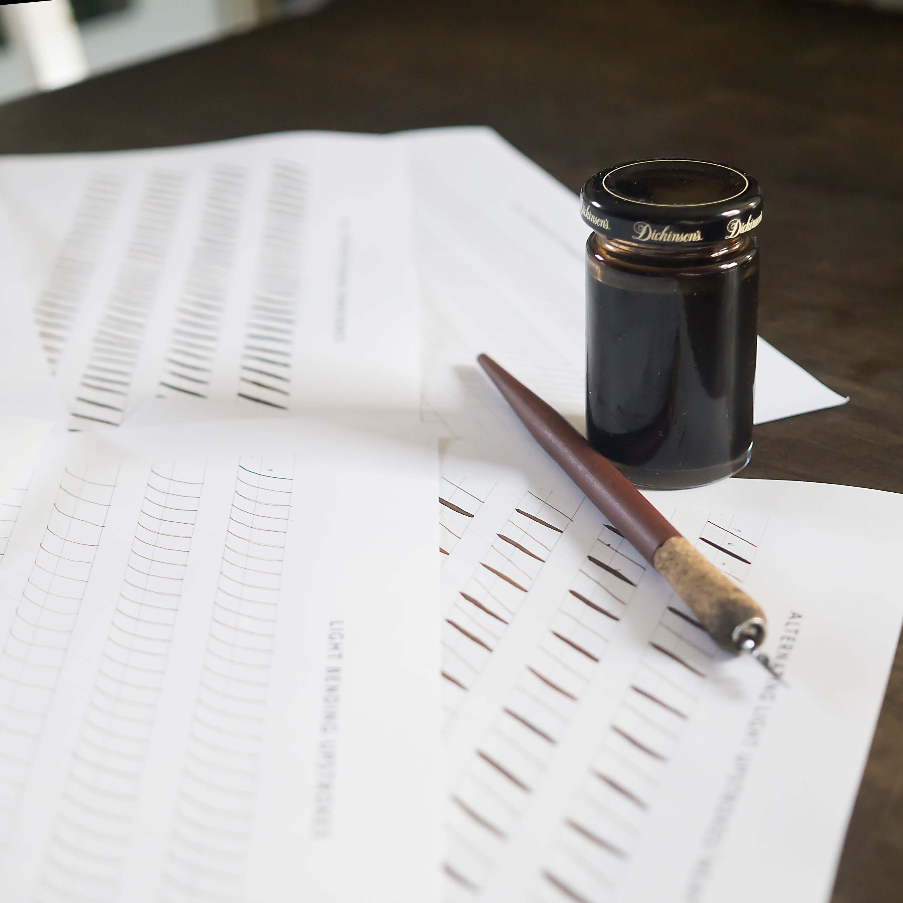 Tintenfeder und Übungsblätter auf Papier — handschriftliche Notizen als Materialtextur